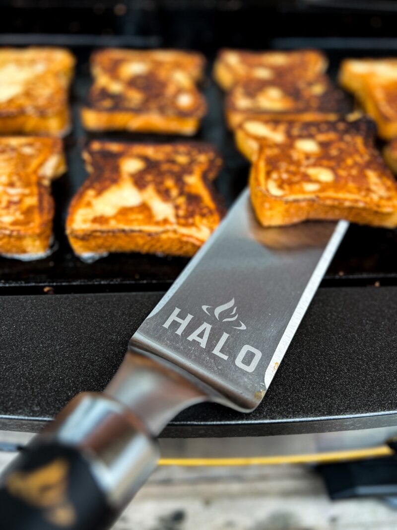 Using a griddle spatula to flip a slice of bread