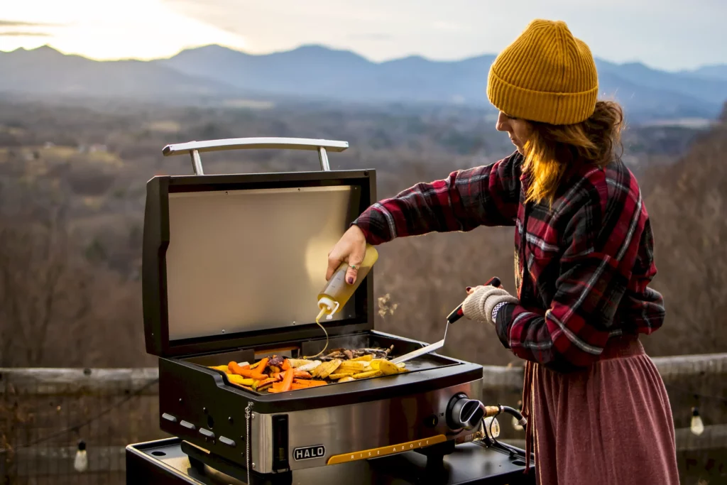 Woman cooking on a portable gas griddle outdoors