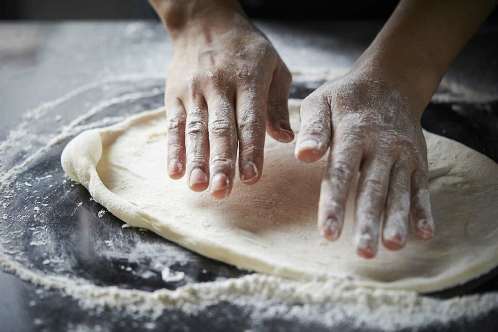 Person working on how to get pizza dough to stretch
